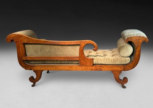 fig 5. Regency simulated rosewood chaise longue with brass inlay, featuring asymmetrical scroll ends, turned brass-castor legs, olive green button-tufted upholstery, and matching bolster cushions.