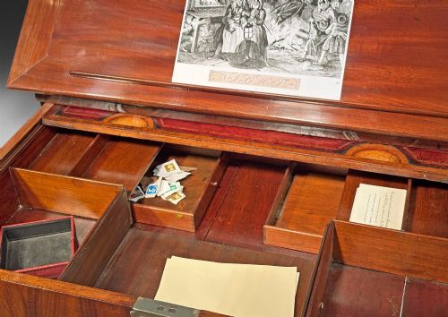 fig 2. A George II mahogany architects table featuring an adjustable ratcheted writing surface, candle slides, pull-out drawer mechanism, and square legs.