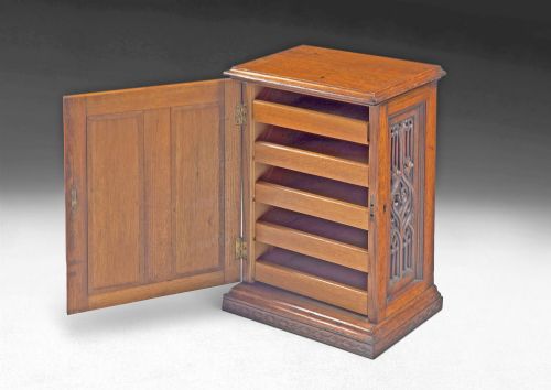 fig 1. A mid-19th-century carved oak tabletop cabinet featuring double doors and side panels decorated with Gothic Revival tracery carvings.