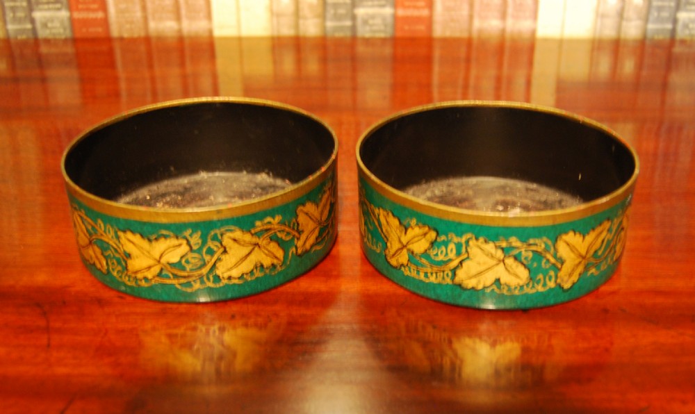 Pair of early 19th. century Toleware decanter coasters with gilt vine decoration on a green ground.