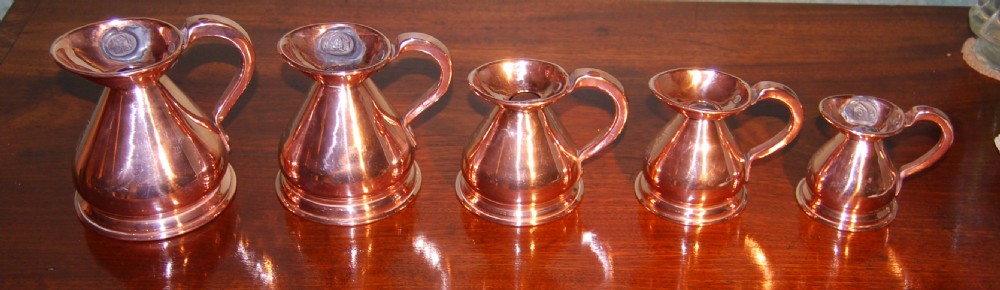 Set of five small copper measures