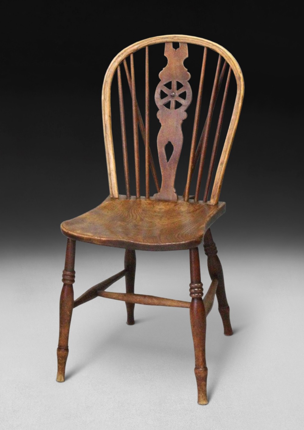 A late 18th century Elm and Oak Low Wheel Back Windsor side chair