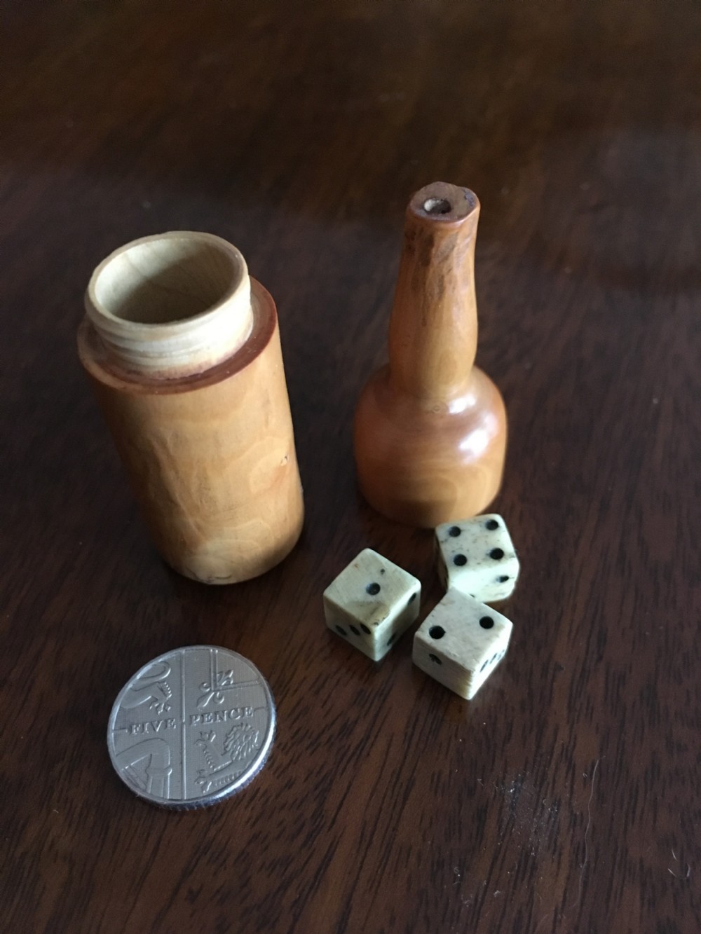 Miniature wooden bottle shaped box containing three small bone dice. View II