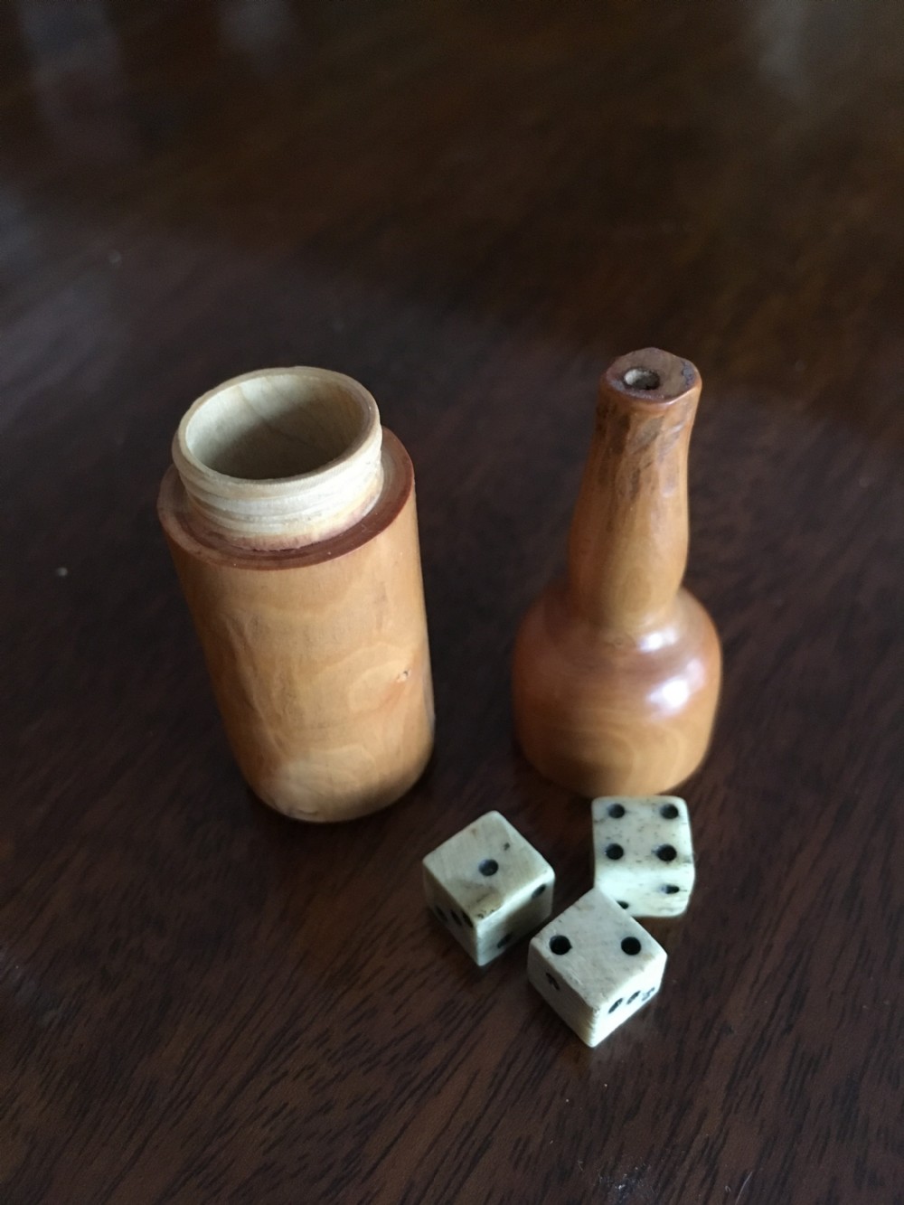 Miniature wooden bottle shaped box containing three small bone dice. View III