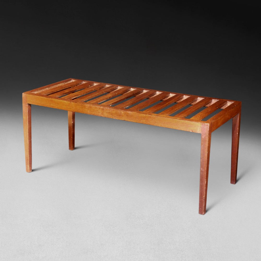A George III period mahogany rectangular bed foot stand featuring four tapered square legs and a cream upholstered top cushion. View II