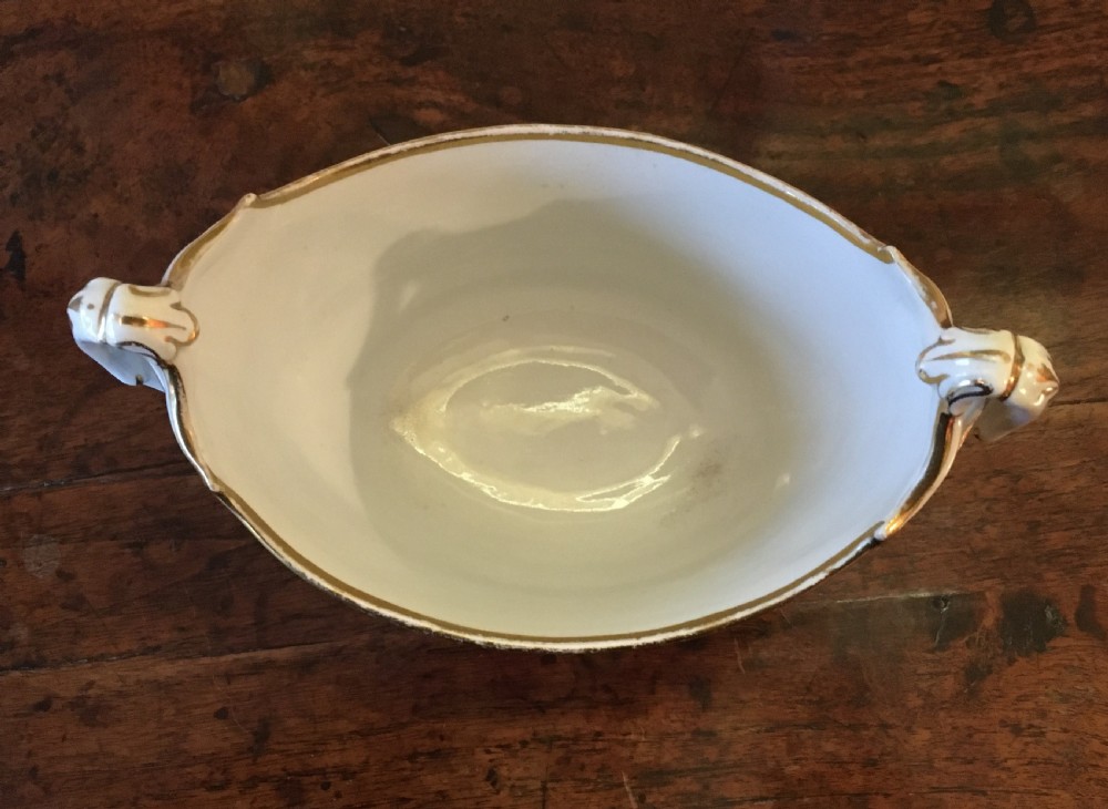 A white boat-shaped antique porcelain sucriere featuring gold leaf foliate scrollwork and twin curved handles. View II