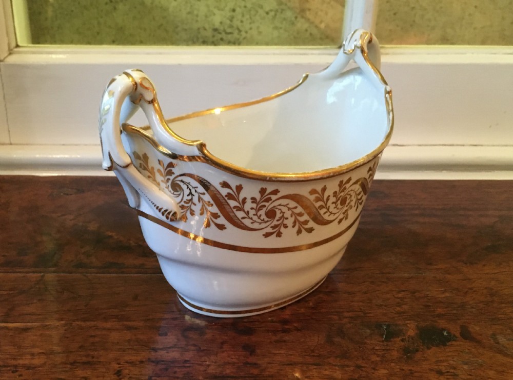 A white boat-shaped antique porcelain sucriere featuring gold leaf foliate scrollwork and twin curved handles. View III