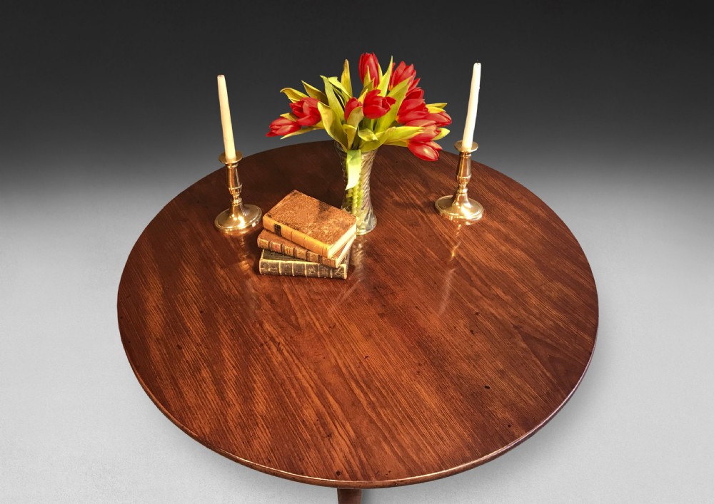 A mid-18th century mahogany tripod centre table featuring a polished circular top supported by a turned stem and three cabriole legs ending in pad feet. View II