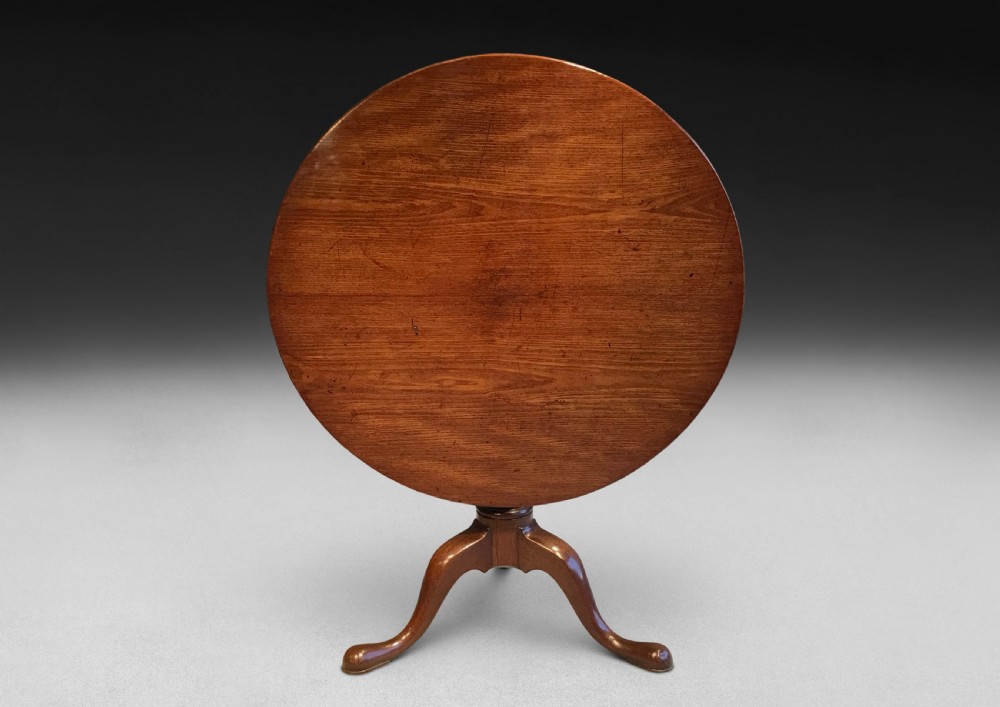 A mid-18th century mahogany tripod centre table featuring a polished circular top supported by a turned stem and three cabriole legs ending in pad feet. View III