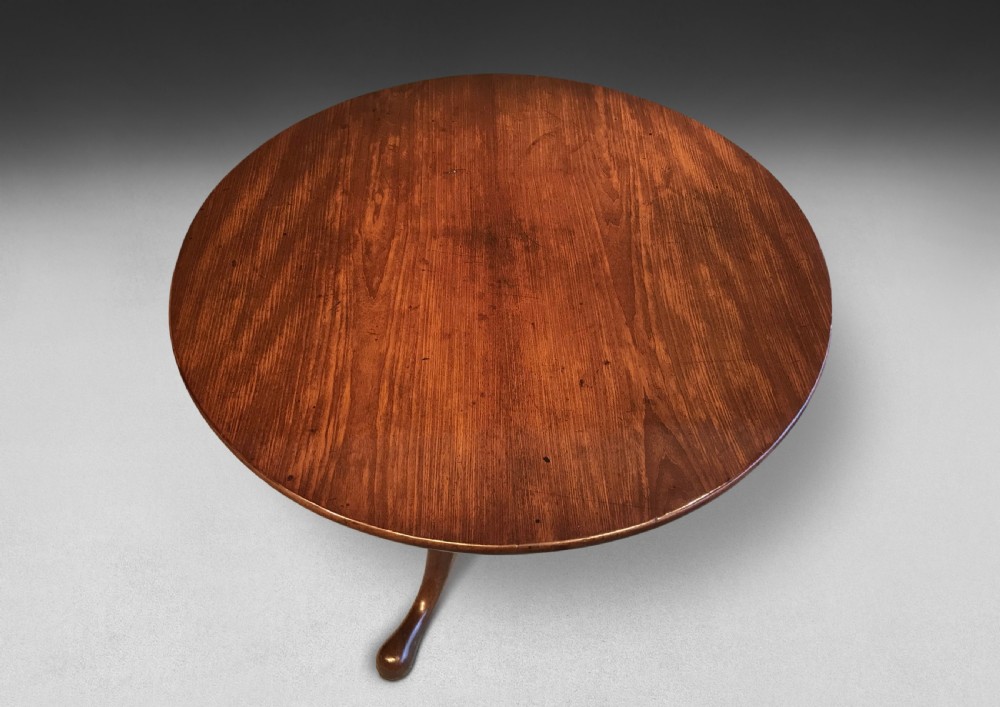 A mid-18th century mahogany tripod centre table featuring a polished circular top supported by a turned stem and three cabriole legs ending in pad feet. View IV