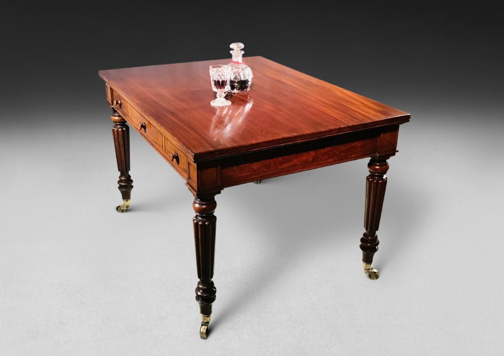A Regency mahogany draw-leaf dining table with extended leaves, reeded legs, and brass cup castors. View VI