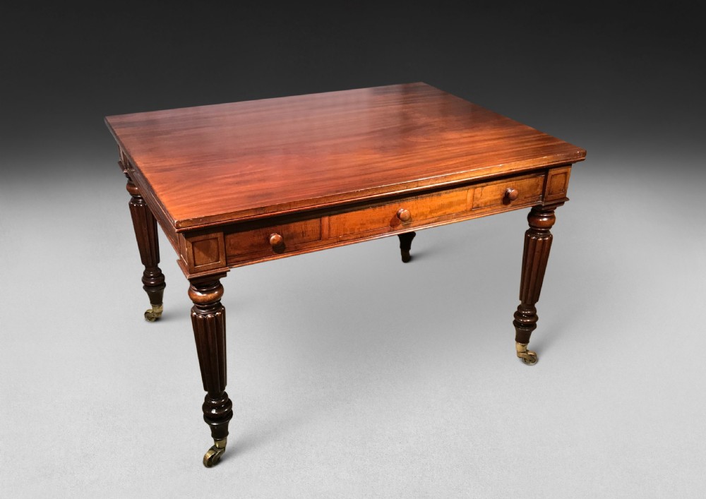 A Regency mahogany draw-leaf dining table with extended leaves, reeded legs, and brass cup castors. View VII