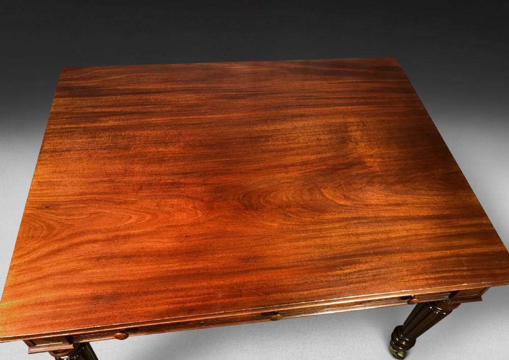 A Regency mahogany draw-leaf dining table with extended leaves, reeded legs, and brass cup castors. View X