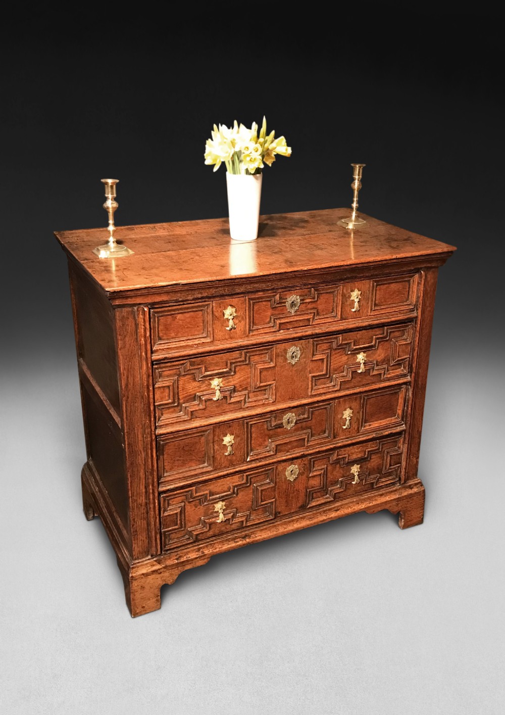 A Jacobean Oak straight fronted chest of four full width drawers