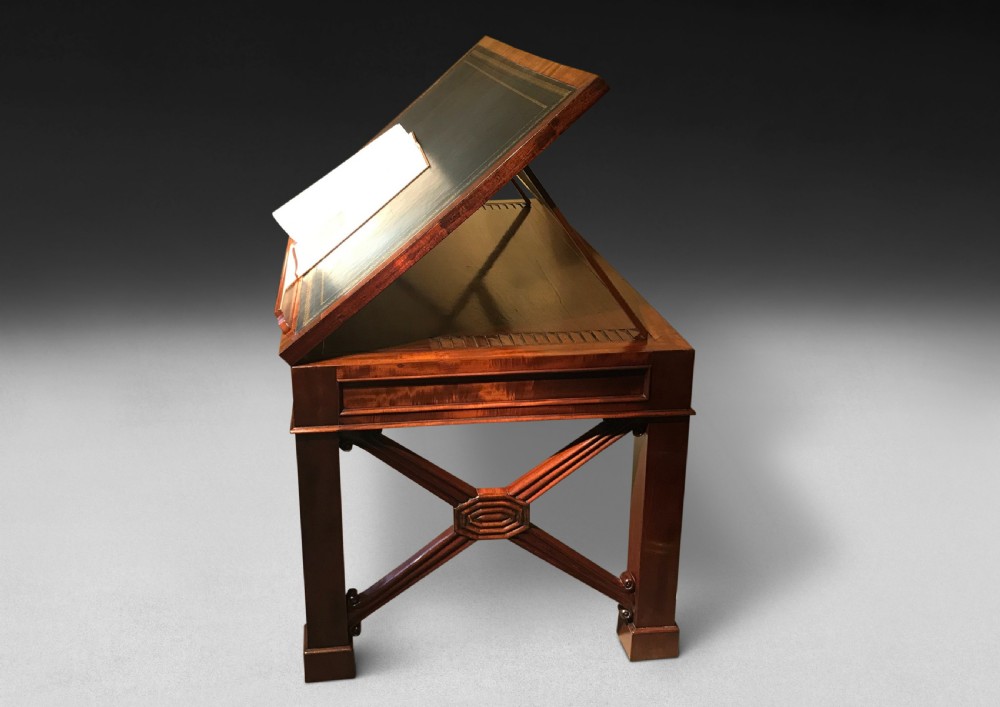 A Regency mahogany library table with a leather writing surface, a low rear gallery, a frieze drawer with brass knobs, and structured end supports. View V