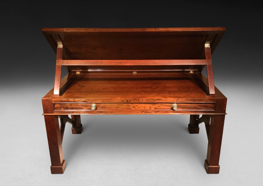 A Regency mahogany library table with a leather writing surface, a low rear gallery, a frieze drawer with brass knobs, and structured end supports. View VI