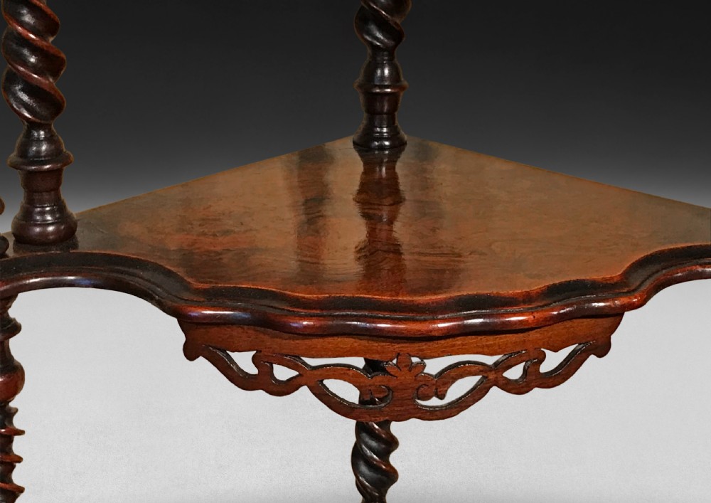 A four-tier Victorian walnut corner whatnot featuring spiral-turned uprights, open fretwork backboard ornamentation, and serpentine shelf fronts. View VI