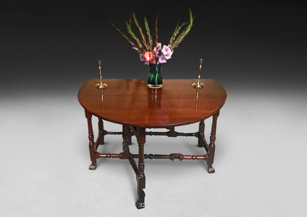 A mahogany Queen Anne gateleg table featuring two drop leaves, turned legs, pad feet, and a central end drawer. View II
