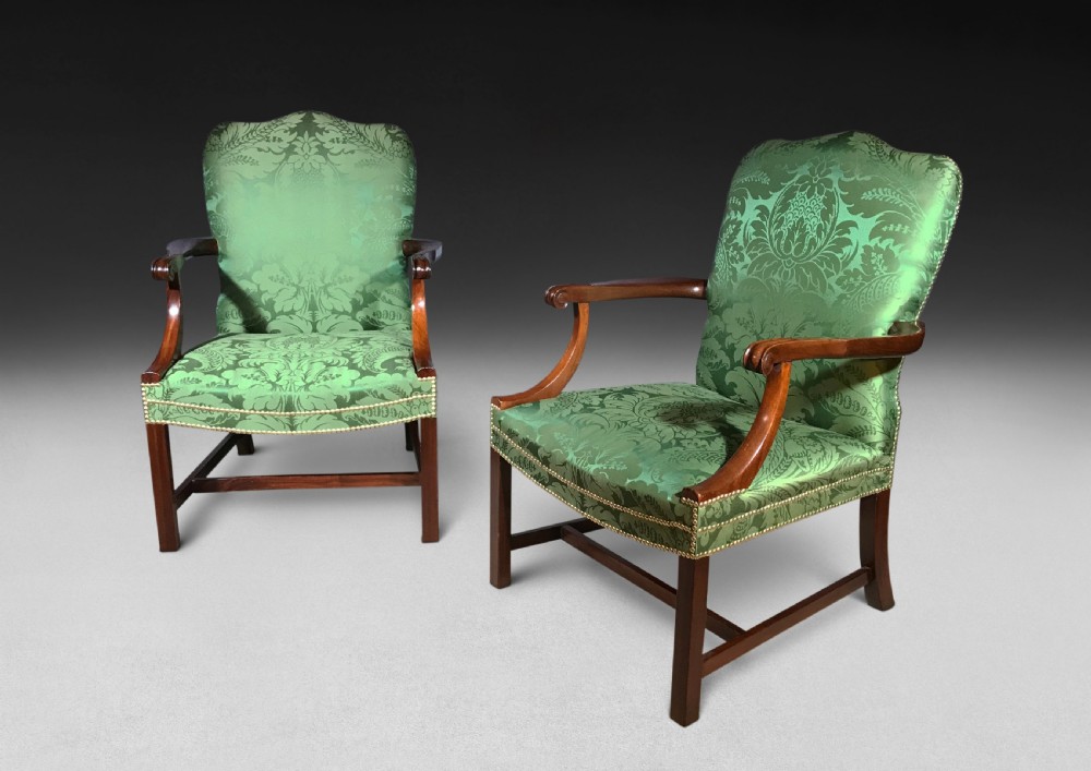 A pair of Chippendale period Gainsborough armchairs with carved mahogany frames, scrolled arms, and green damask upholstery trimmed with brass studs. View II