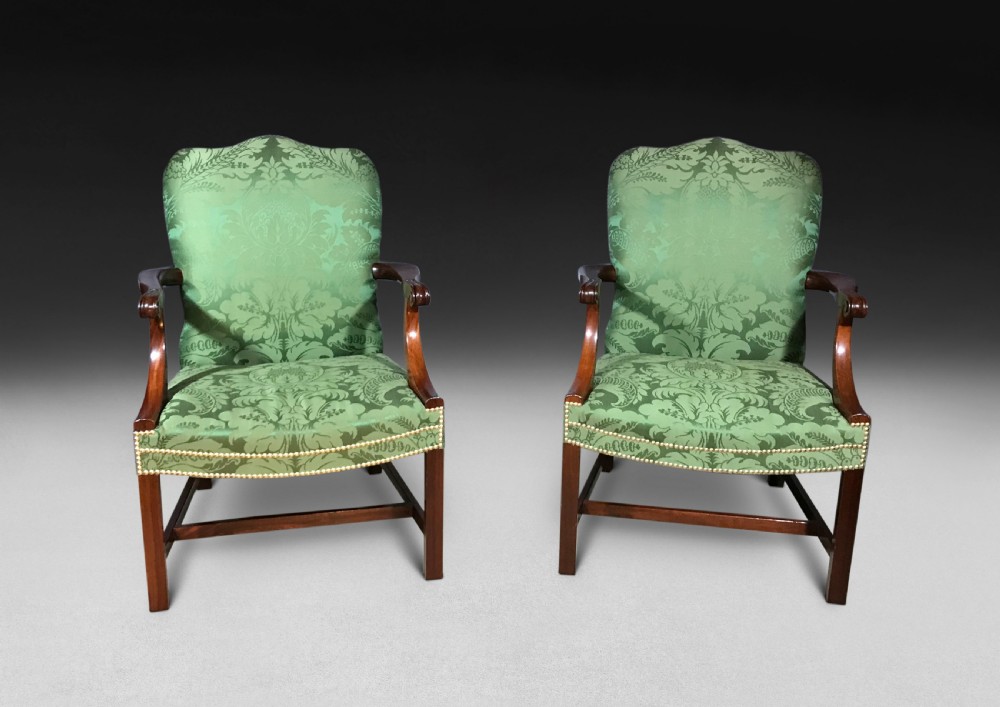 A pair of Chippendale period Gainsborough armchairs with carved mahogany frames, scrolled arms, and green damask upholstery trimmed with brass studs. View III