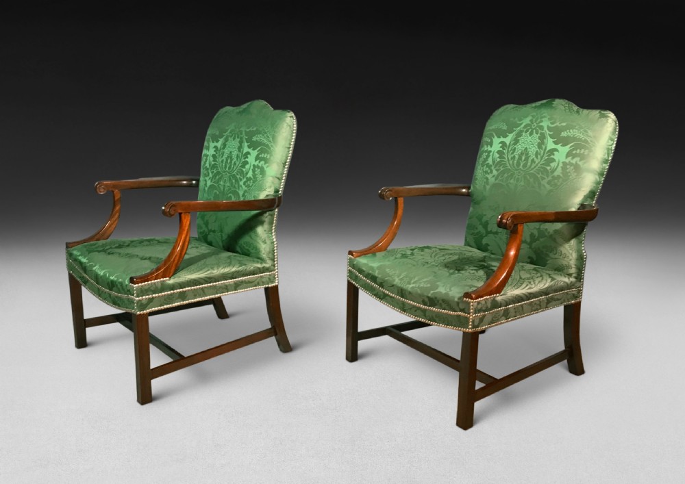 A pair of Chippendale period Gainsborough armchairs with carved mahogany frames, scrolled arms, and green damask upholstery trimmed with brass studs. View VIII