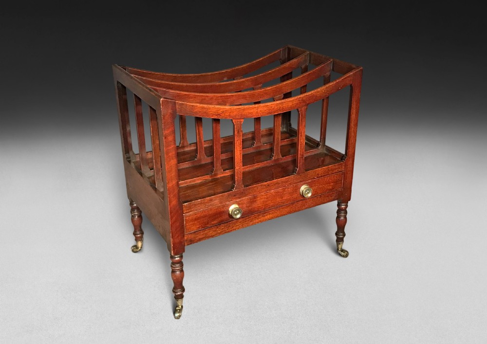 A Regency period mahogany Canterbury featuring three curved compartments, a single lower drawer with brass knobs, turned legs, and brass castors. View III