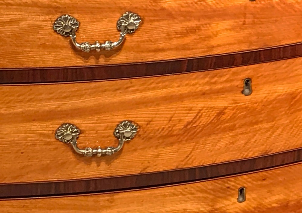 A George III period bowfront satinwood chest of drawers featuring kingwood crossbanding and four graduated drawers on bracket feet. View V