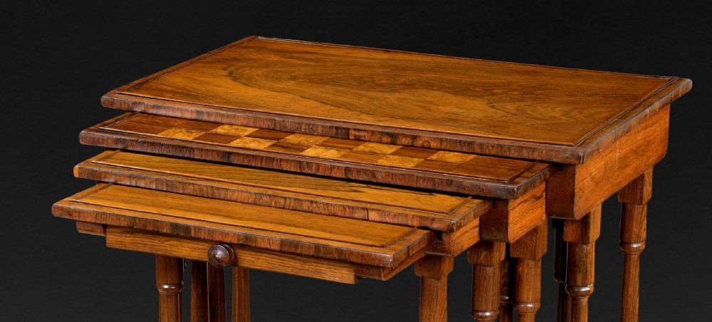 A set of four nested Regency rosewood quartetto tables featuring turned spindle legs, twin-ring stretchers, and an inlaid chessboard on the second surface. View IV