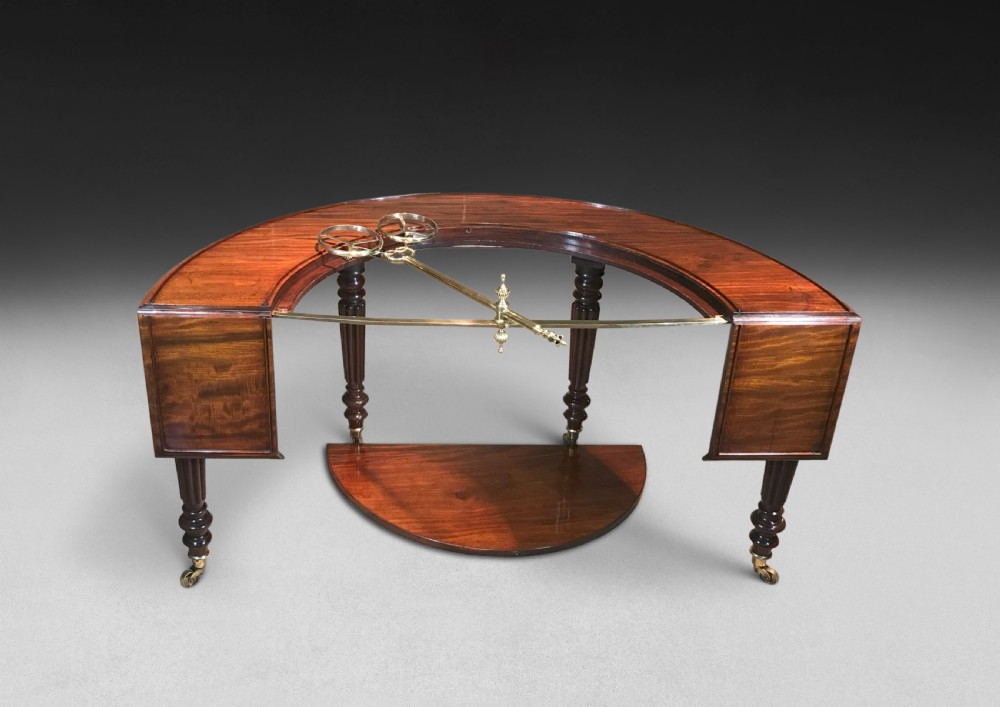 A horseshoe-shaped Regency mahogany hunt table featuring reeded turned legs with brass castors. View VIII