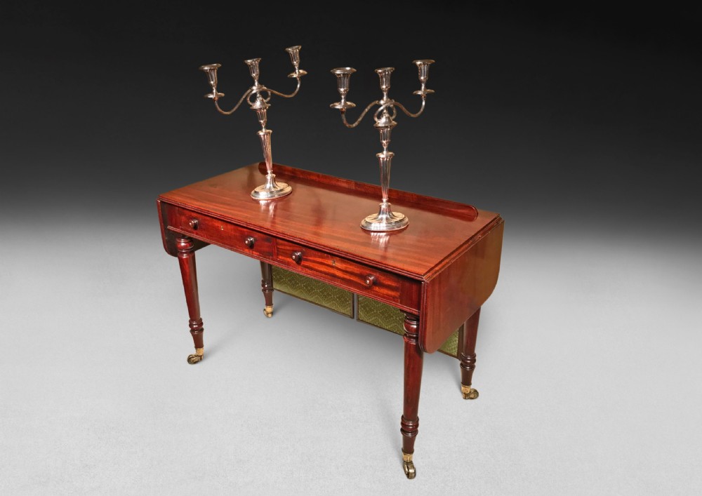 A Regency mahogany sofa writing table featuring two drop flaps, two frieze drawers, turned legs on brass castors, and an adjustable green fabric screen. View IV