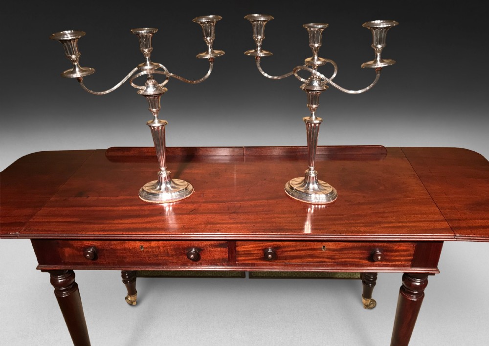 A pair of silver George III period three-light Old Sheffield Plate candelabra featuring curved reeded branches, fluted stems, and oval bases. View II
