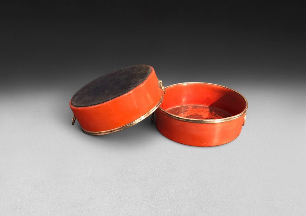 A pair of circular Regency period red papier-mache wine coasters with brass rims and brass side ring handles. View III