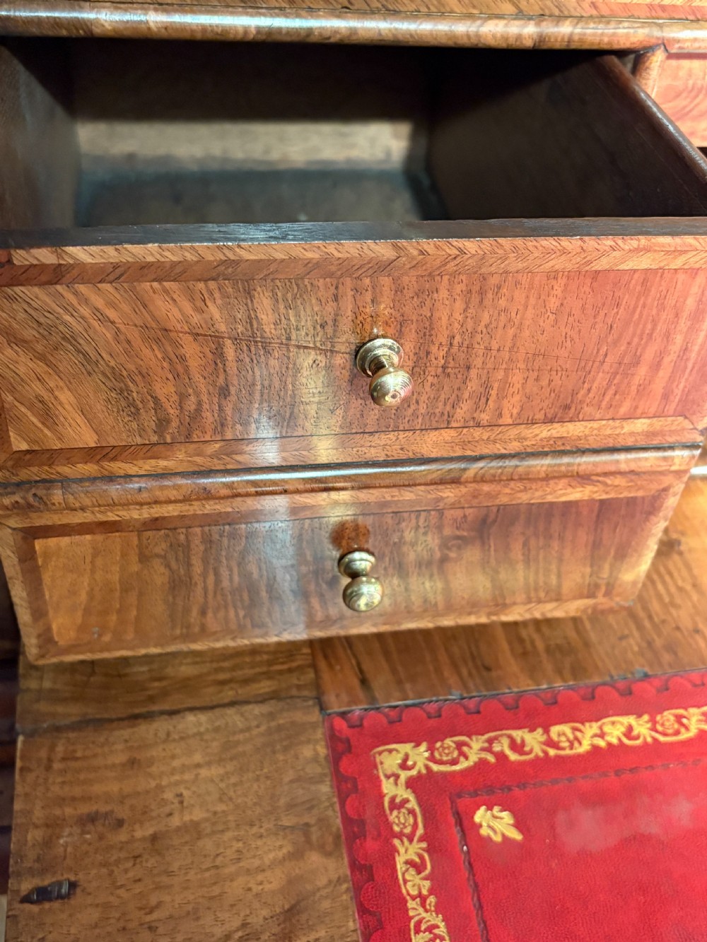 A William and Mary period walnut escritoire featuring a fall-front upper cabinet above a lower chest of drawers on bun feet. View VI