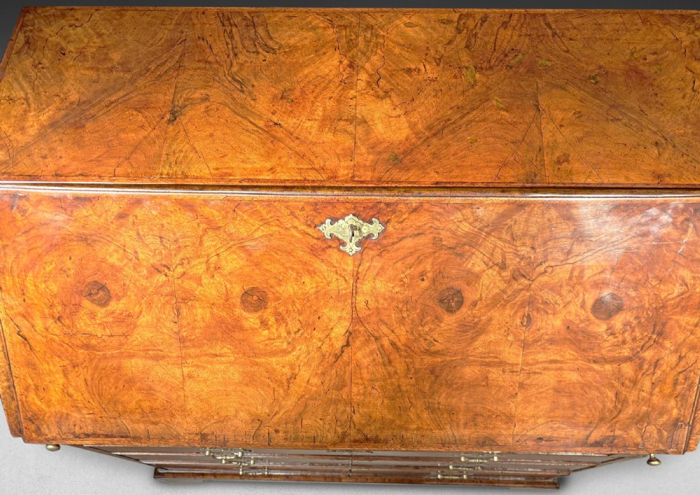 An early 18th-century George I slant-front bureau crafted from figured walnut with brass drop handles, keyhole escutcheons, and bracket feet. View II