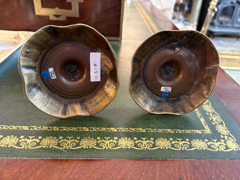 A pair of mid-18th century cast brass candlesticks featuring turned baluster stems and shaped scalloped bases. View III