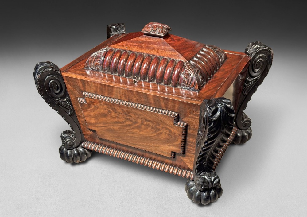 A Regency Carved Mahogany and Ebonised cellarette in the manner of Thomas Hope