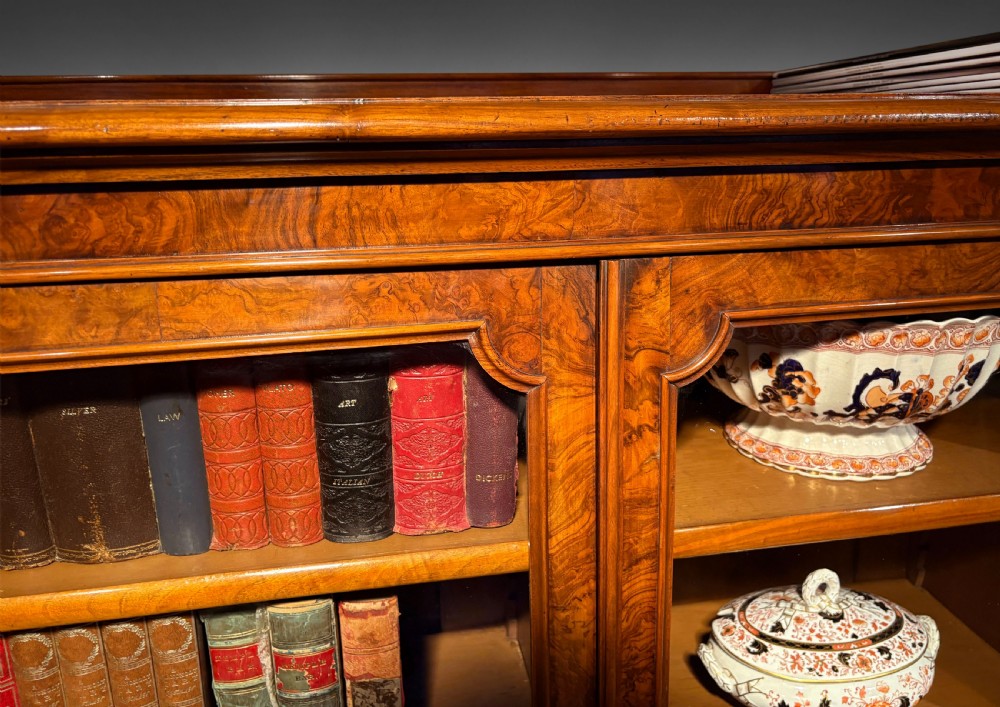 A pair of low Victorian walnut glazed bookcases featuring three arched glass doors and a plinth base. View IV