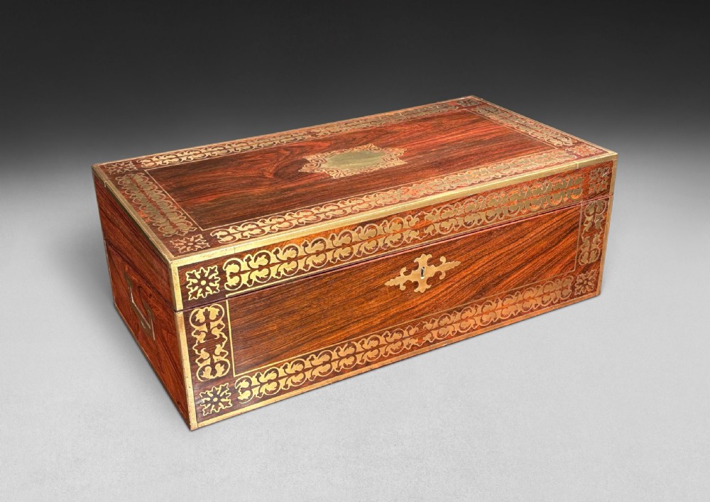 An opened Regency rosewood writing slope featuring brass inlay, brass candle sockets, side handles, and a dark leather writing surface. View V