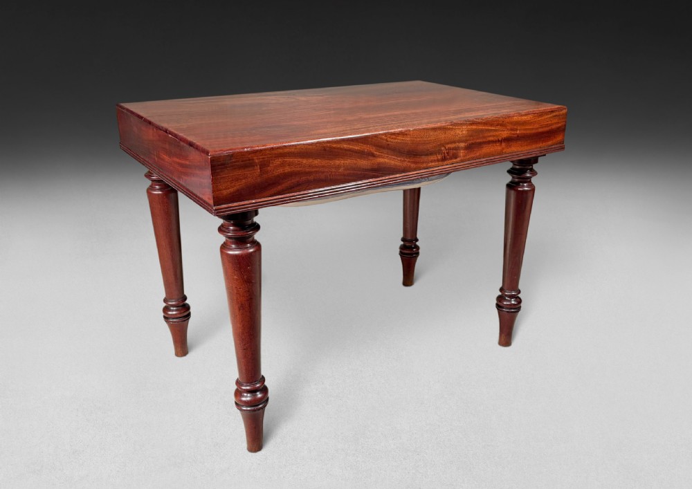 A Regency mahogany bidet table featuring a removable rectangular lid, deep reeded aprons, and turned tapered legs.