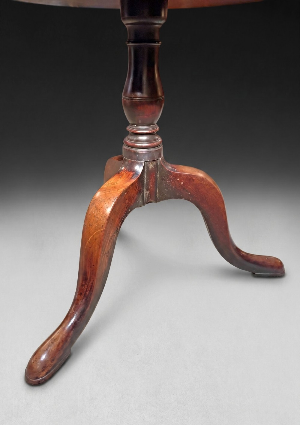 A George III mahogany three-tier dumb waiter featuring graduated circular trays on a turned central column supported by a tripod base. View VII