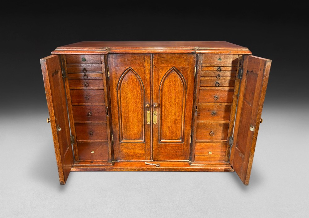 A nineteenth-century oak tabletop collectors cabinet featuring breakfront doors with carved Gothic arch panels and turned wooden knobs. View III