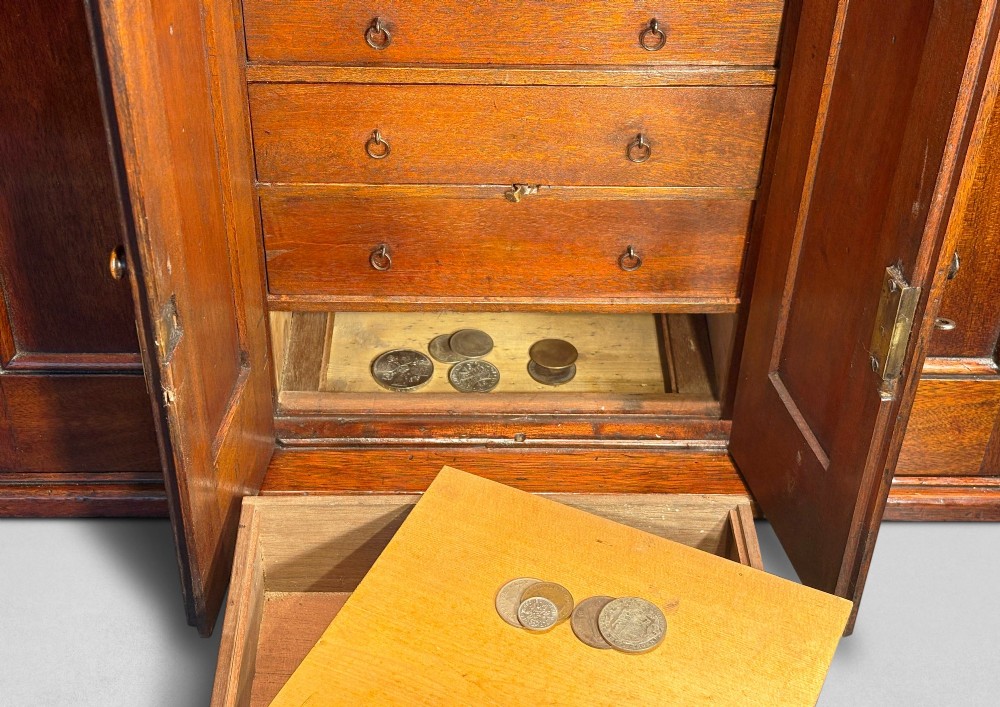 A nineteenth-century oak tabletop collectors cabinet featuring breakfront doors with carved Gothic arch panels and turned wooden knobs. View VI