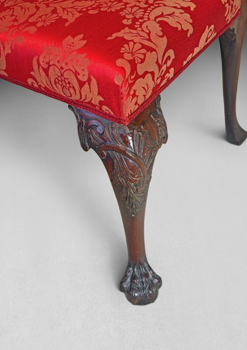 A pair of carved mahogany Chippendale style side chairs with pierced splats, cabriole legs, and red patterned damask upholstered seats. View II