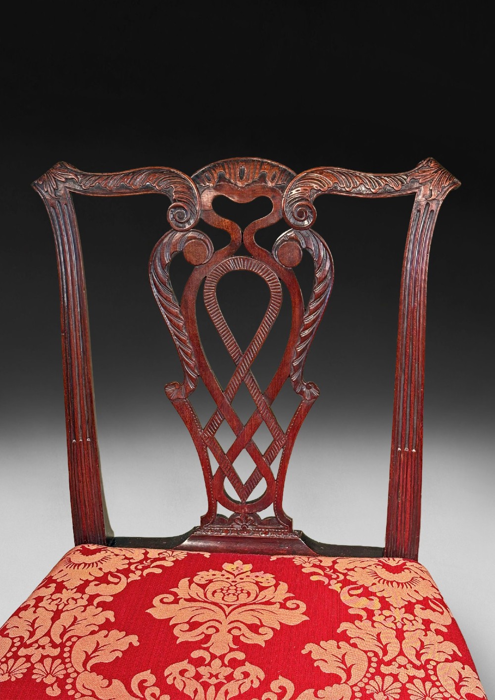A pair of carved mahogany Chippendale style side chairs with pierced splats, cabriole legs, and red patterned damask upholstered seats. View III