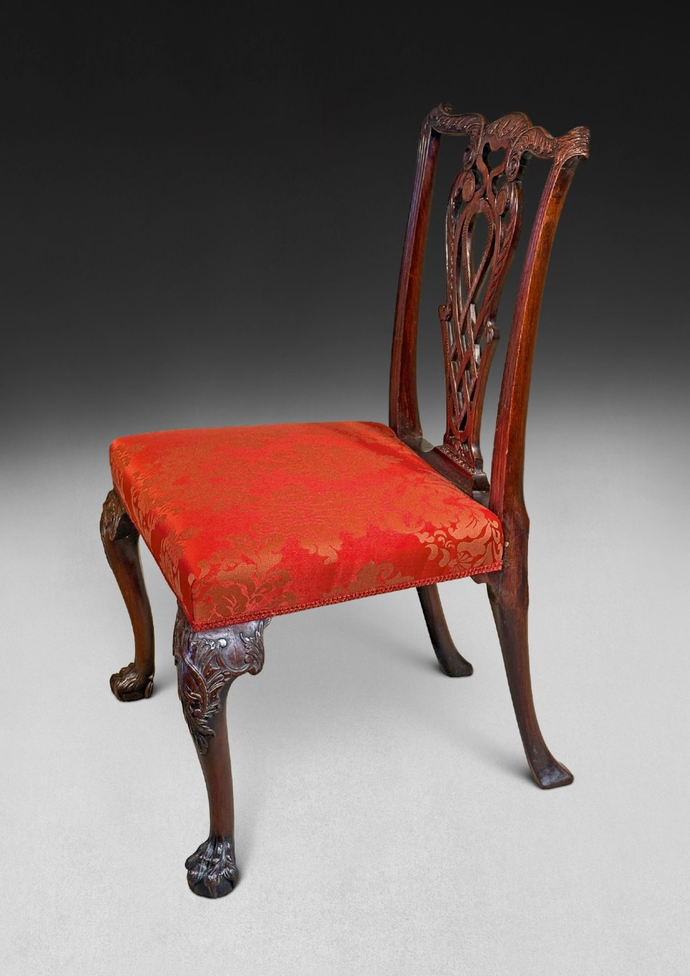 A pair of carved mahogany Chippendale style side chairs with pierced splats, cabriole legs, and red patterned damask upholstered seats. View IV
