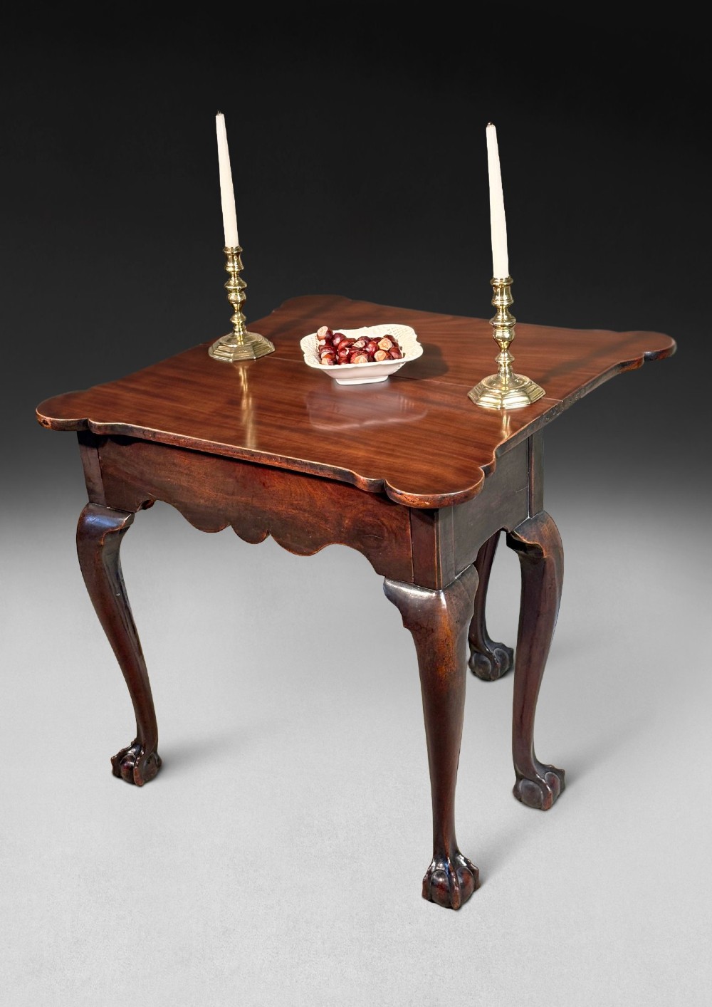 An eighteenth-century George II mahogany foldover tea table featuring cabriole legs terminating in hand-carved ball and claw feet. View II