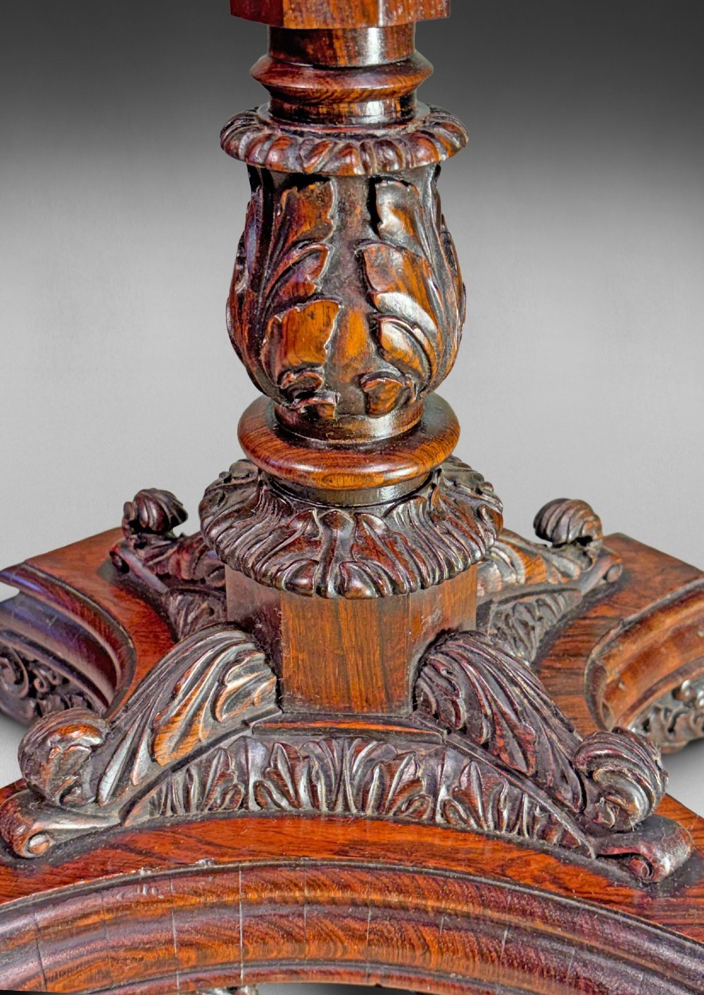 An antique Regency rosewood octagonal wine table with a faceted central column and a carved quadform base. View V