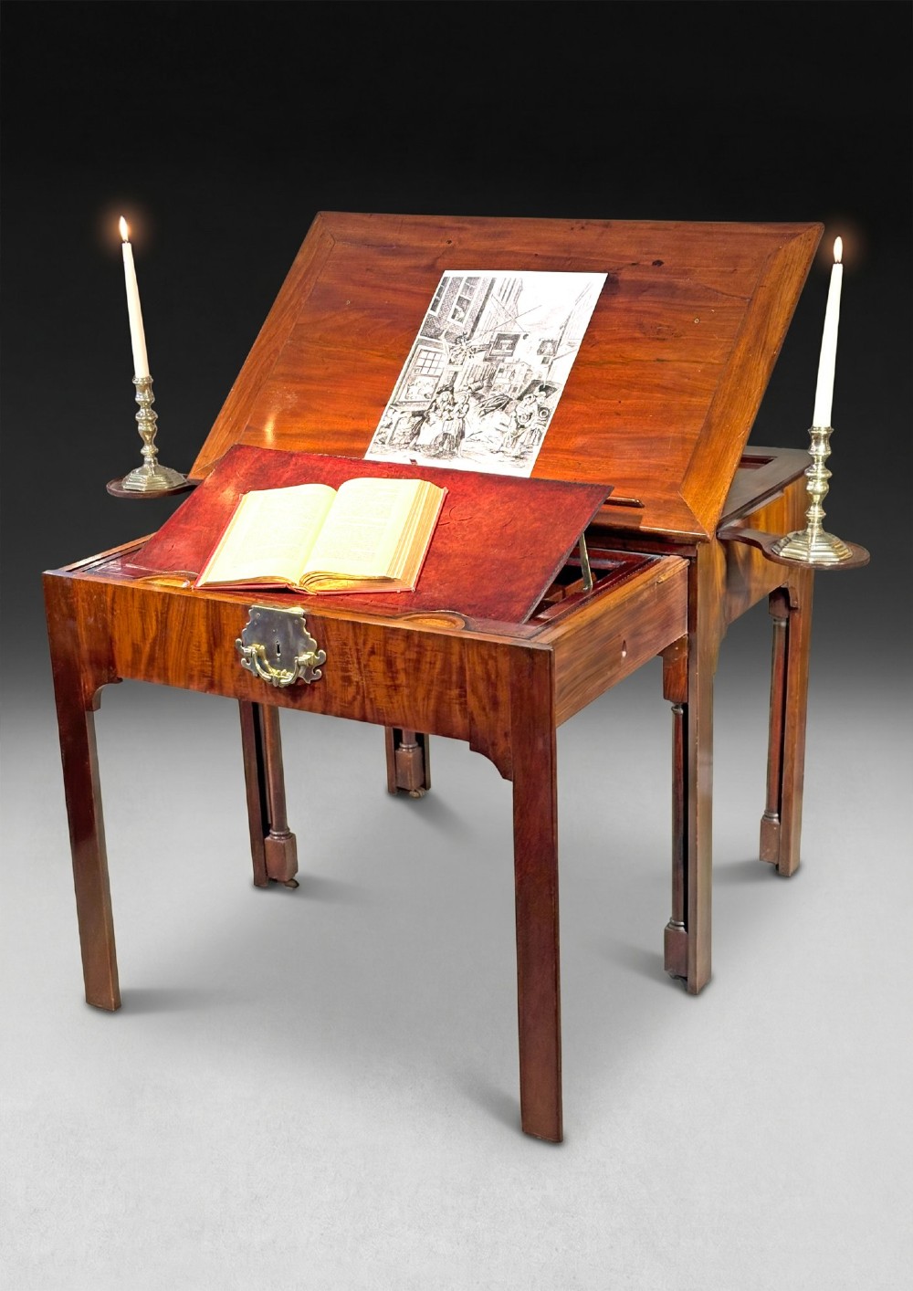 A George II mahogany architects table featuring an adjustable ratcheted writing surface, candle slides, pull-out drawer mechanism, and square legs.