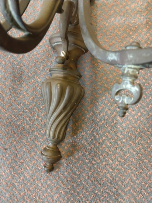 fig 1. A pair of patinated three-arm solid brass wall sconces featuring fluted urn-shaped backplates and curved candle branches.