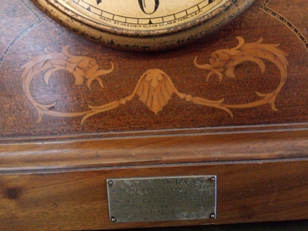 An Edwardian dome top mahogany mantel clock featuring floral marquetry inlay, brass side columns, and an Arabic numeral dial. View III